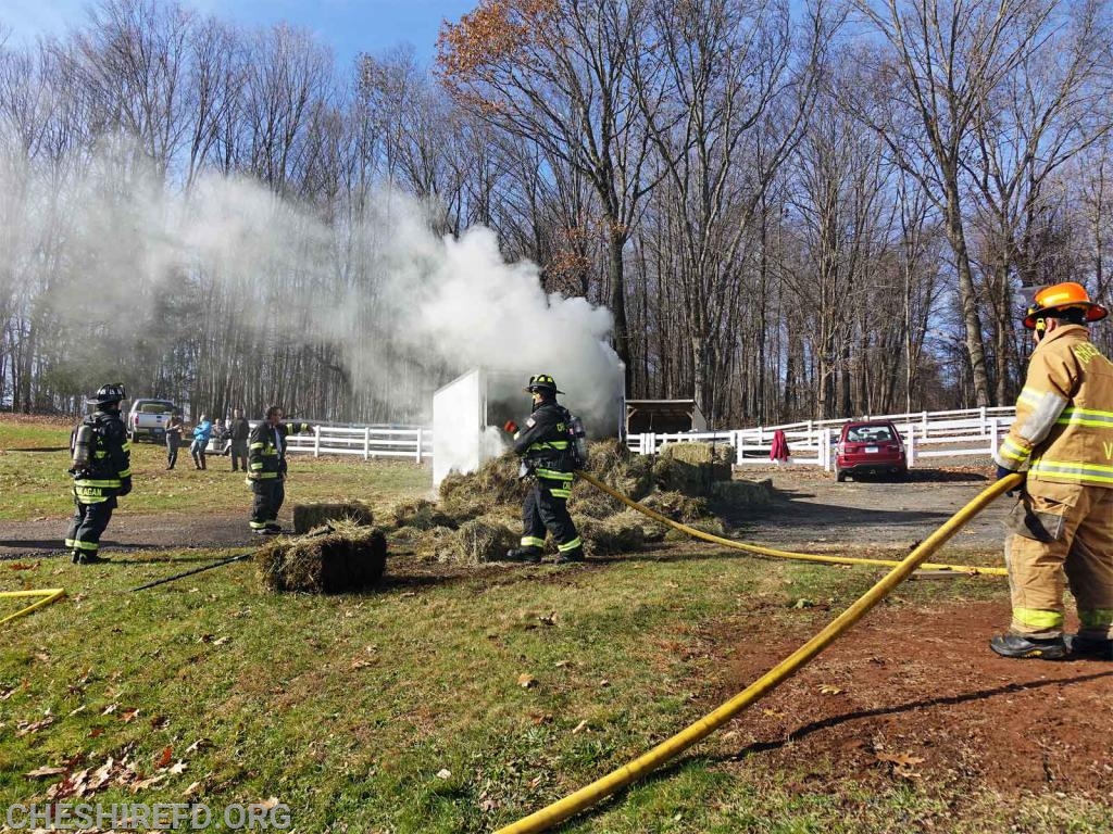 A trailer loaded with hay caught fire on Saturday. On arrival there was smoke billowing from inside trailer. The hay had caught fire and burned on the interior middle of the packed load. The fire was difficult to extinguish due to the packed hay and gaining access and moving the water soaked hay out of the trailer. Eventually a machine was used to remove some of the remaining burning hay. The CFD shuttled water due to no hydrants in the area. Multiple gallons of water was used to fully extinguish. The fire department was on scene for approximately 1.5 hours fully extinguishing the fire.