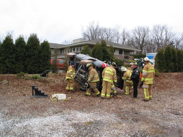 CFD Fire Fighters operate at the scene of a motor vehicle on its side on a property off of Highland Avenue.