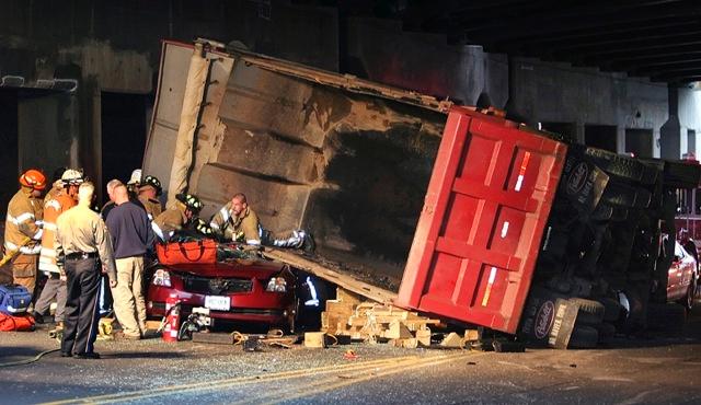 Cheshire Fire Fighters operate at the scene of a dump truck that rolled onto several occupied vehicles. Waterbury Road at the I-84 overpass.