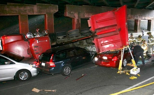 Cheshire Fire Fighters operate at the scene of a dump truck that rolled onto several occupied vehicles. Waterbury Road and the I-84 overpass.